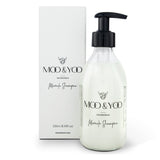 A bottle of Miracle Shampoo by MOO & YOO with a pump dispenser, placed next to its packaging box.