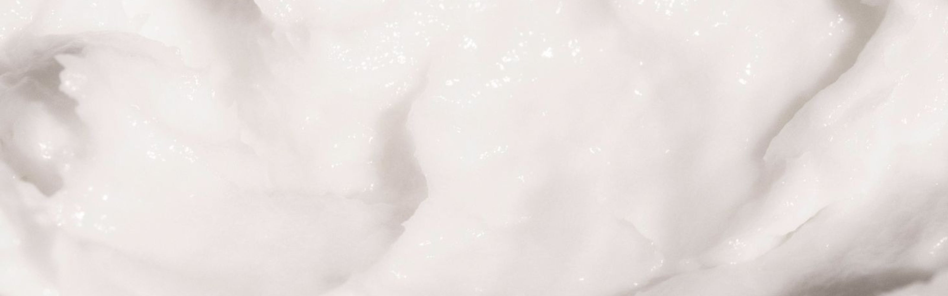 Close-up of white miracle hair mask texture.