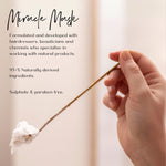 Hand holding a gold metal spoon with hair mask on the end with text aabout product details on a light background