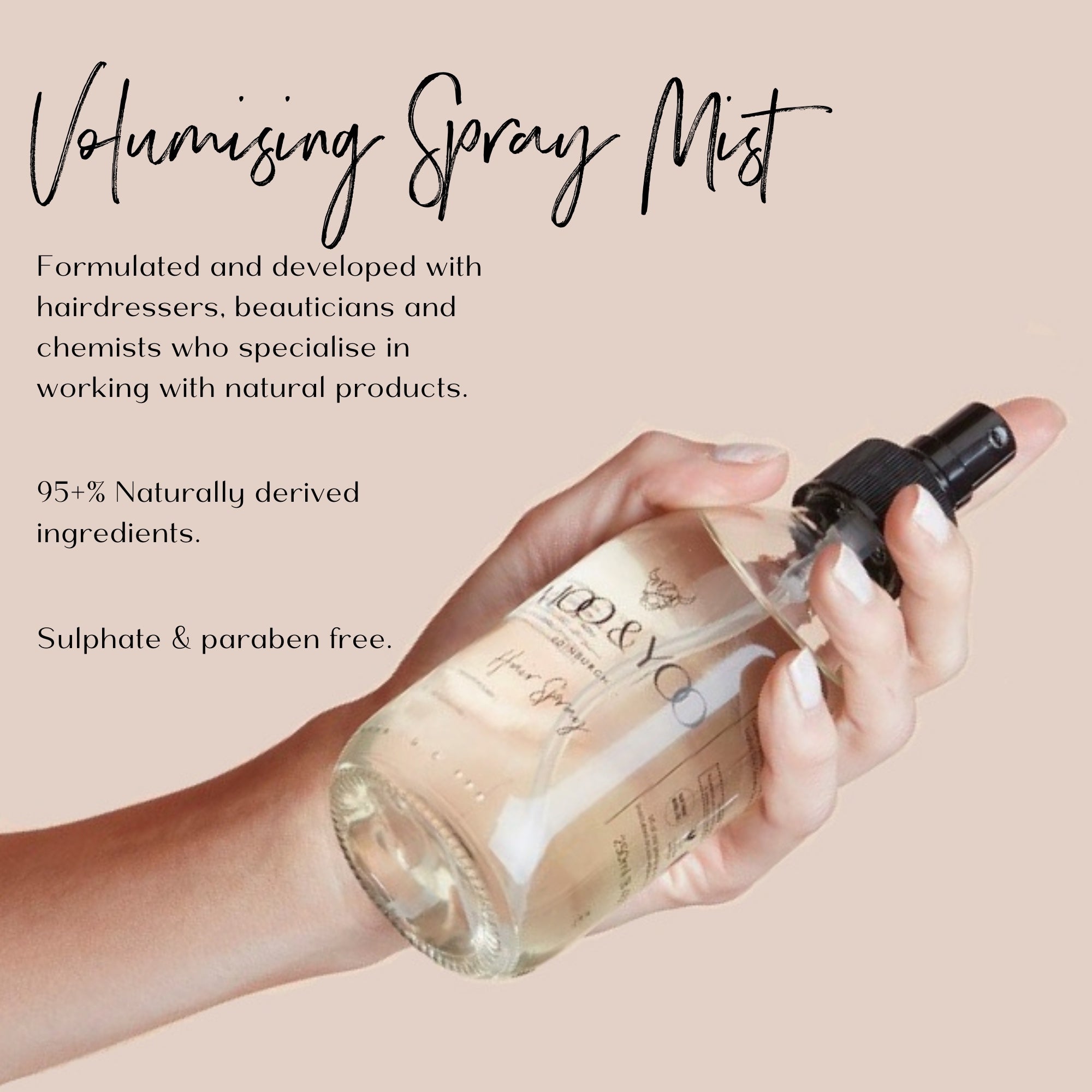Hand holding a volumising spray mist bottle with product details on a beige background