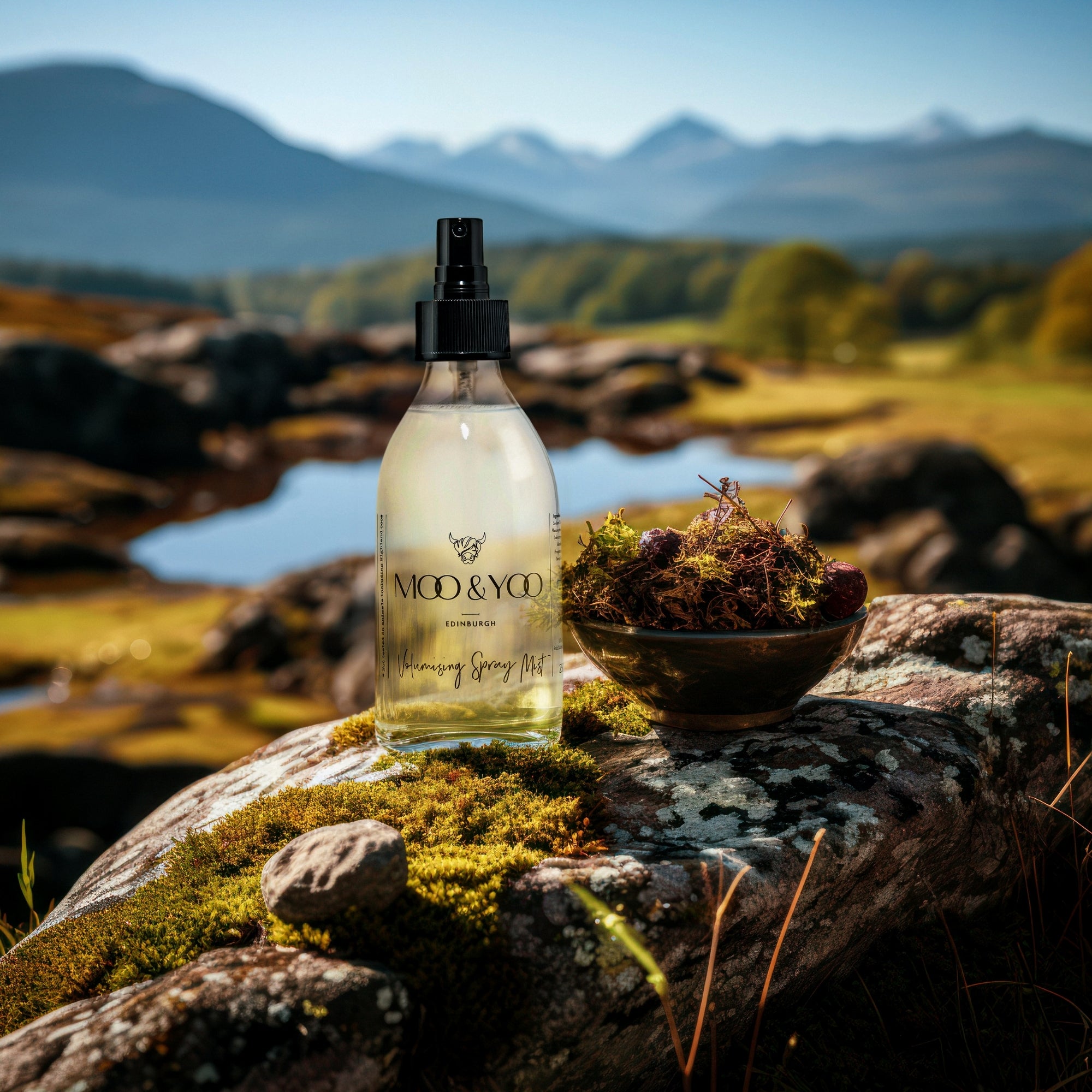 Bottle of Moo & Yoo volumising spray mist on a rock with a scenic background of Scottish munros and wetland