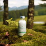 Glass bottle of Moo and Yoo Miracle Body Lotion on moss in a forest.