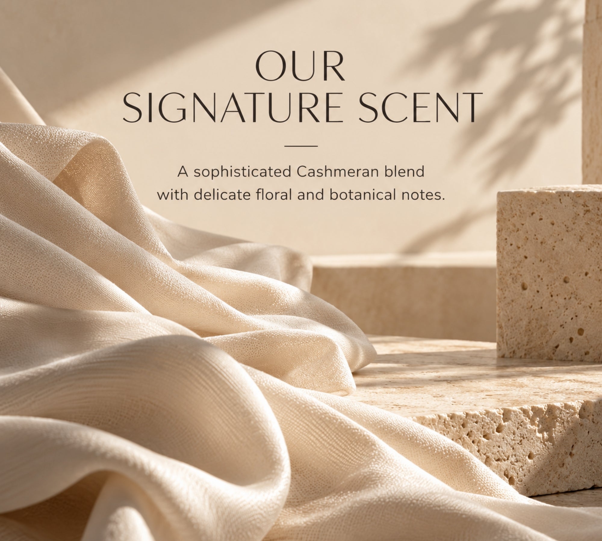 A warm beige promotional graphic with draped cream fabric, stone blocks, and shadow play, plus the text 'OUR SIGNATURE SCENT' and a short descriptive blurb about a Cashmeran blend with floral and botanical notes.