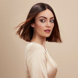 Female model with a super straight brunette bob from using Moo and Yoo Miracle Conditioner and Miracle Milk. She has super shiny hair. She is looking at the camera and is wearing a neutral coloured blouse