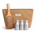 A hair care gift set from MOO & YOU featuring a natural woven pouch with a 'simple wish' label, a wooden paddle hairbrush engraved with the brand name, and three silver travel mini bottles of haircare products in the front.