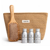 A hair care gift set from MOO & YOU featuring a natural woven pouch with a 'simple wish' label, a wooden paddle hairbrush engraved with the brand name, and three silver travel mini bottles of haircare products in the front.