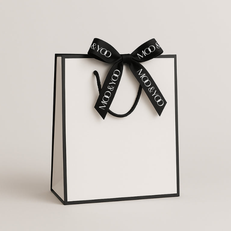 premium cream moo & yoo bespoke gift bag with black trim and a black ribbon with the moo & yoo logo in white on it