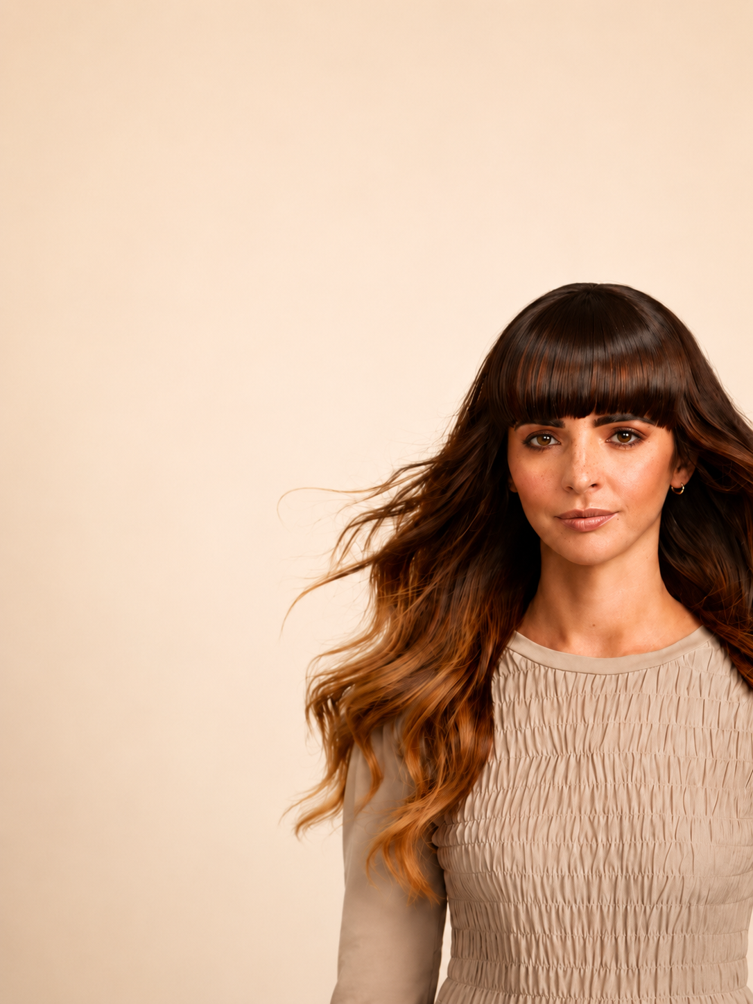 girl with long flowing brunette hair flowing in the wind with a sleek shiny straight fringe facing the camera directly. Natural skin and freckles 
