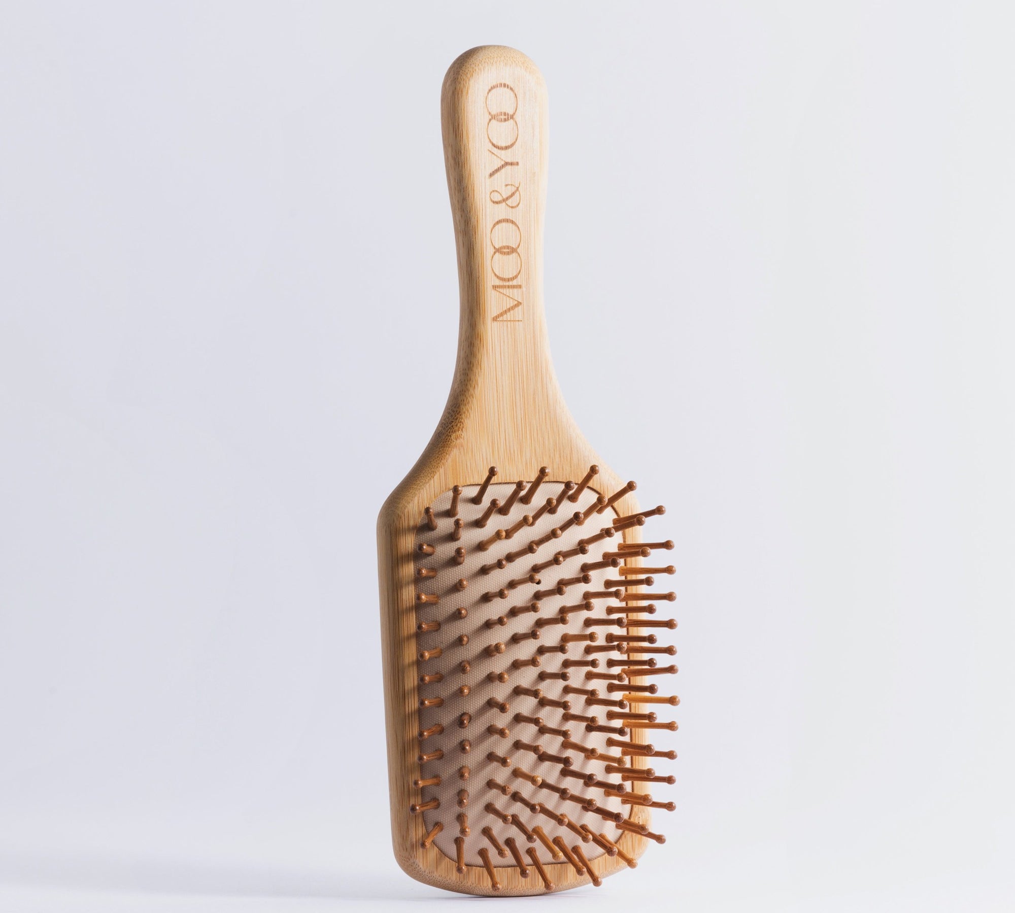 Moi and Yoo bamboo paddle brush with the logo on the handle.