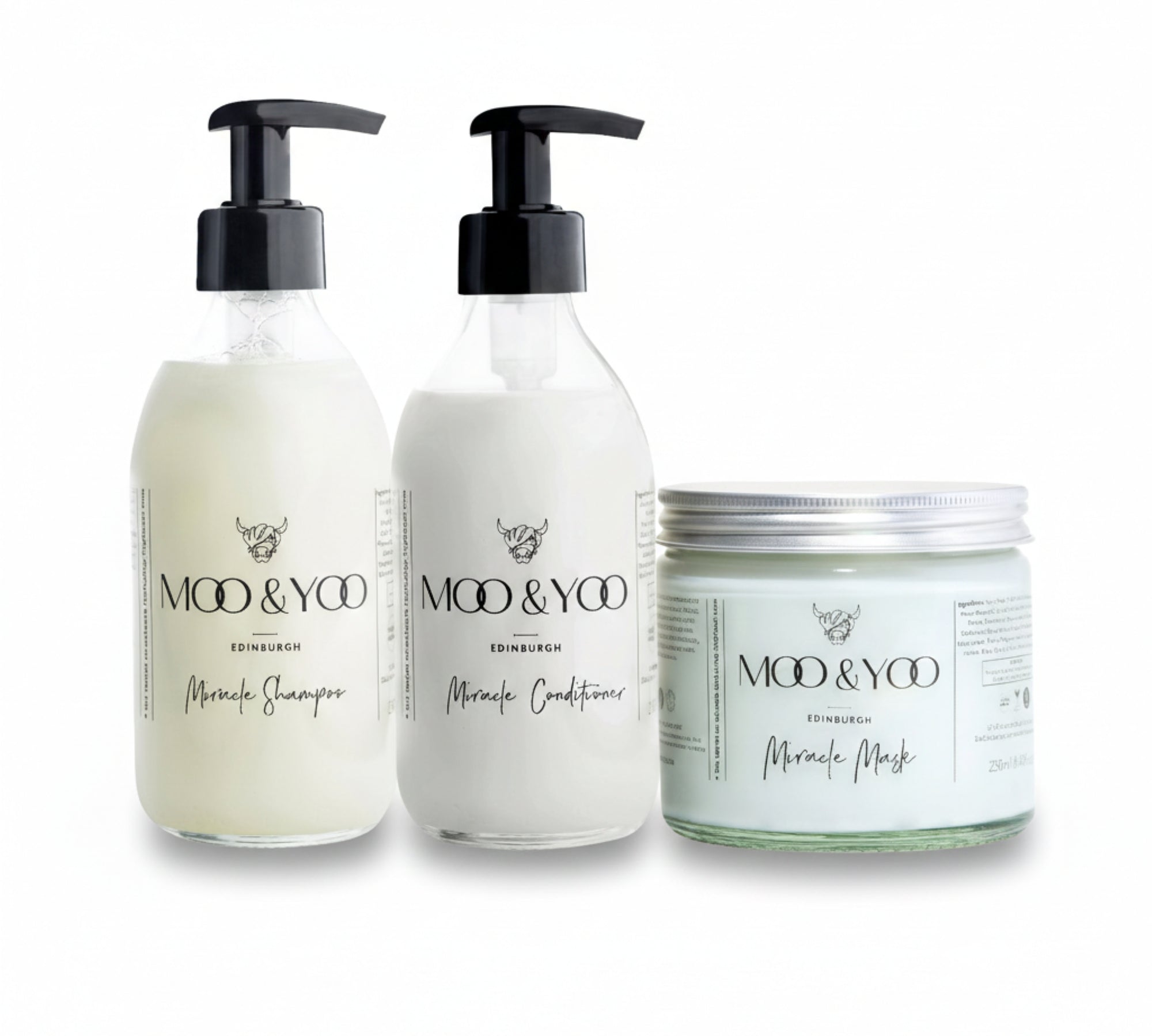Two glass bottles and a glass jar of Moo and Yoo products sitting side by side. It is a Miracle Shampoo, Conditioner and a Miracle mask.  They are on a white background