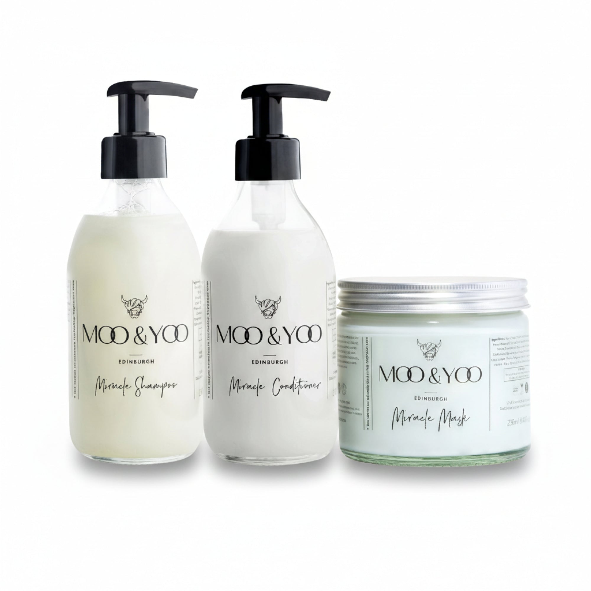 Two glass bottles and a glass jar of Moo and Yoo products sitting side by side. It is a Miracle Shampoo, Conditioner and a Miracle mask.  They are on a white background