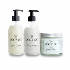 Two glass bottles and a glass jar of Moo and Yoo products sitting side by side. It is a Miracle Shampoo, Conditioner and a Miracle mask.  They are on a white background