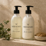 Moo & Yoo Miracle Shampoo and Conditioner in glass bottles displayed in a natural stone shower setting.