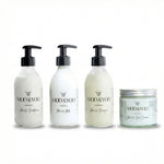 four products in glass bottles lined up next to each other, our miracle conditioner, miracle milk, miracle shampoo and miracle curl cream all against a white background 