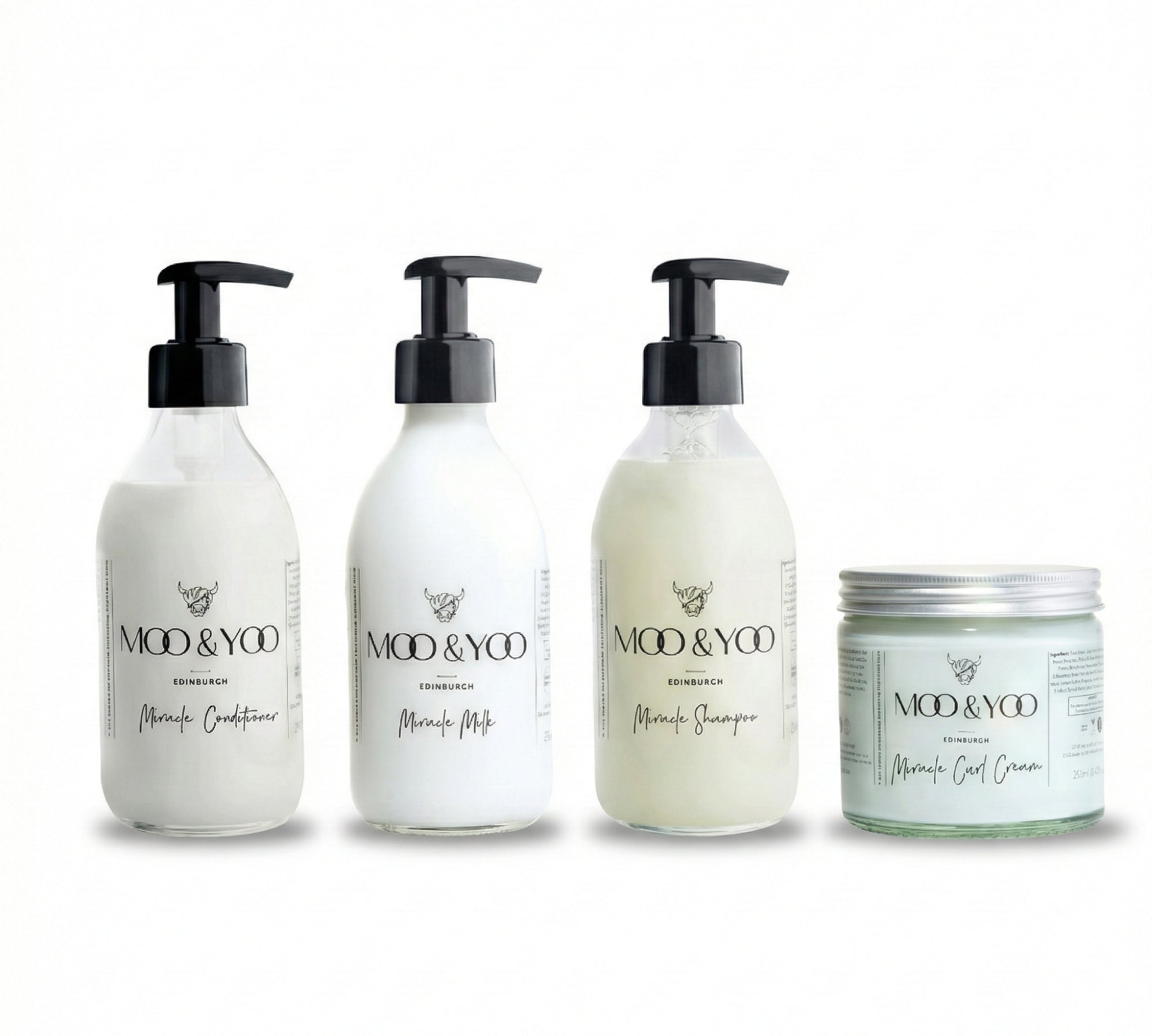 four products in glass bottles lined up next to each other, our miracle conditioner, miracle milk, miracle shampoo and miracle curl cream all against a white background 