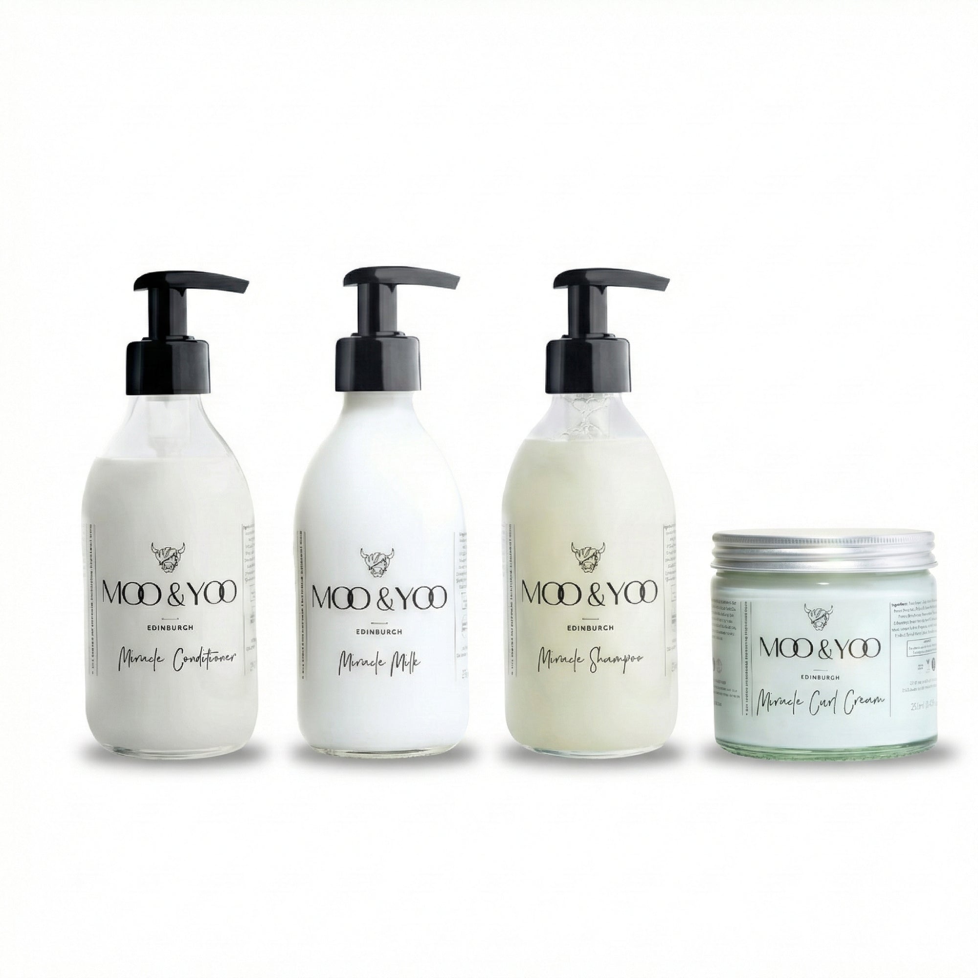 four products in glass bottles lined up next to each other, our miracle conditioner, miracle milk, miracle shampoo and miracle curl cream all against a white background 