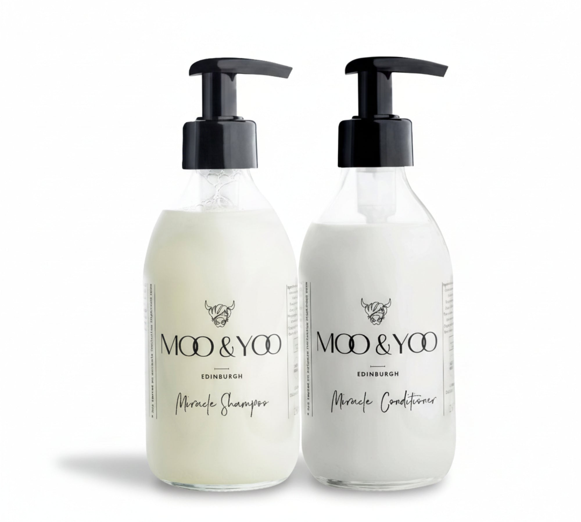 A glass bottle of Moo and Yoo Miracle Conditioner and a glass bottle of Moo and Yoo Miracle Shampoo sitting side by side with pumps on a white background 