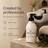 A bottle of MOD & YOO Professional Hair Conditioner with a black pump dispenser, set on a marble counter in a warm, professional salon environment with a shampoo sink and towels in the background.