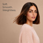 A woman with a shoulder-length brown bob haircut wearing a pale pink knit sweater, shown against a warm beige background with the text 'Soft. Smooth.