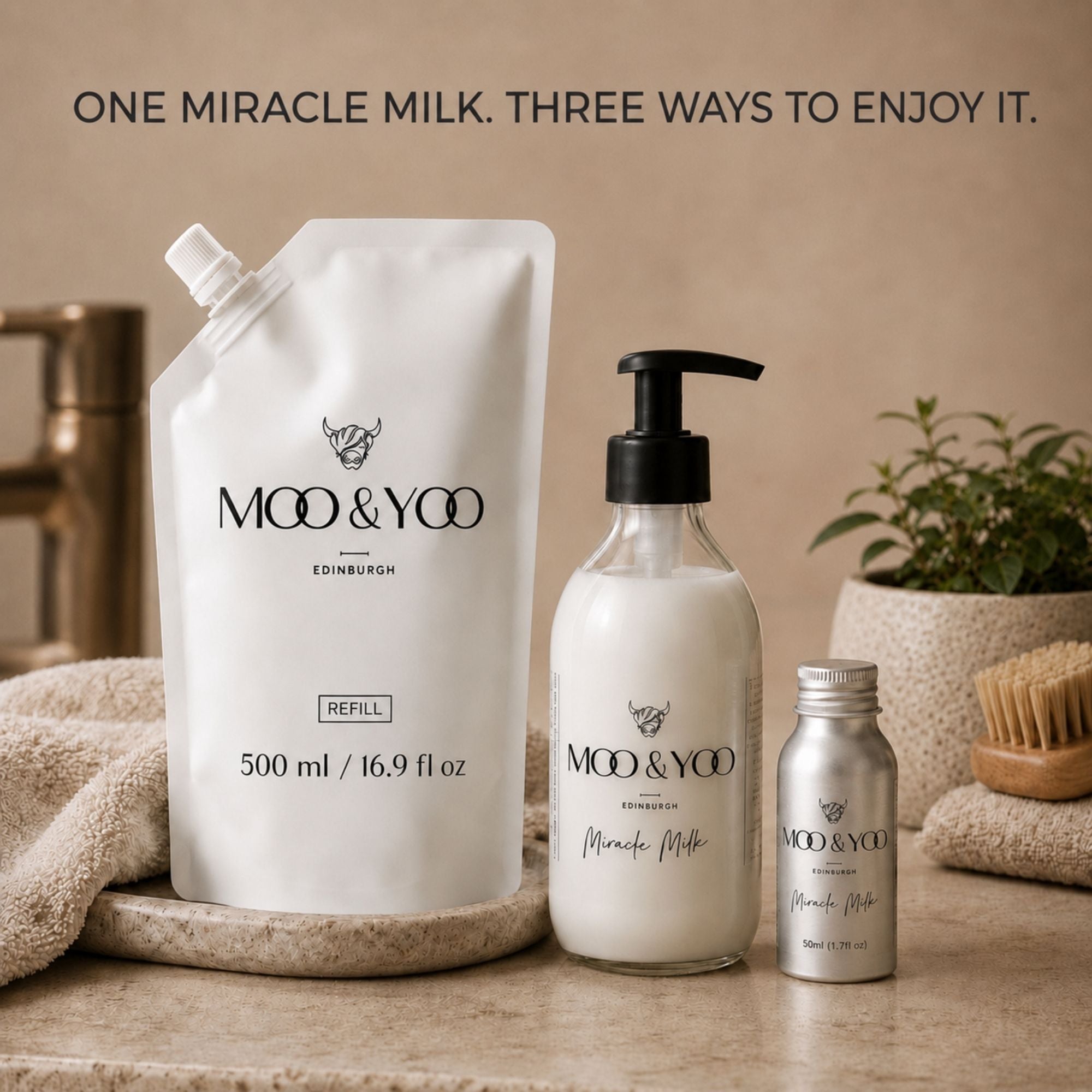 Three MOO & YOO Edinburgh 'Miracle Milk' products arranged on a stone surface: a large white refill pouch, a white pump glass bottle, and a small silver aluminimum travel sized bottle, with towels, a plant, and a brush in the background. Text at the top reads 'ONE MIRACLE MILK.