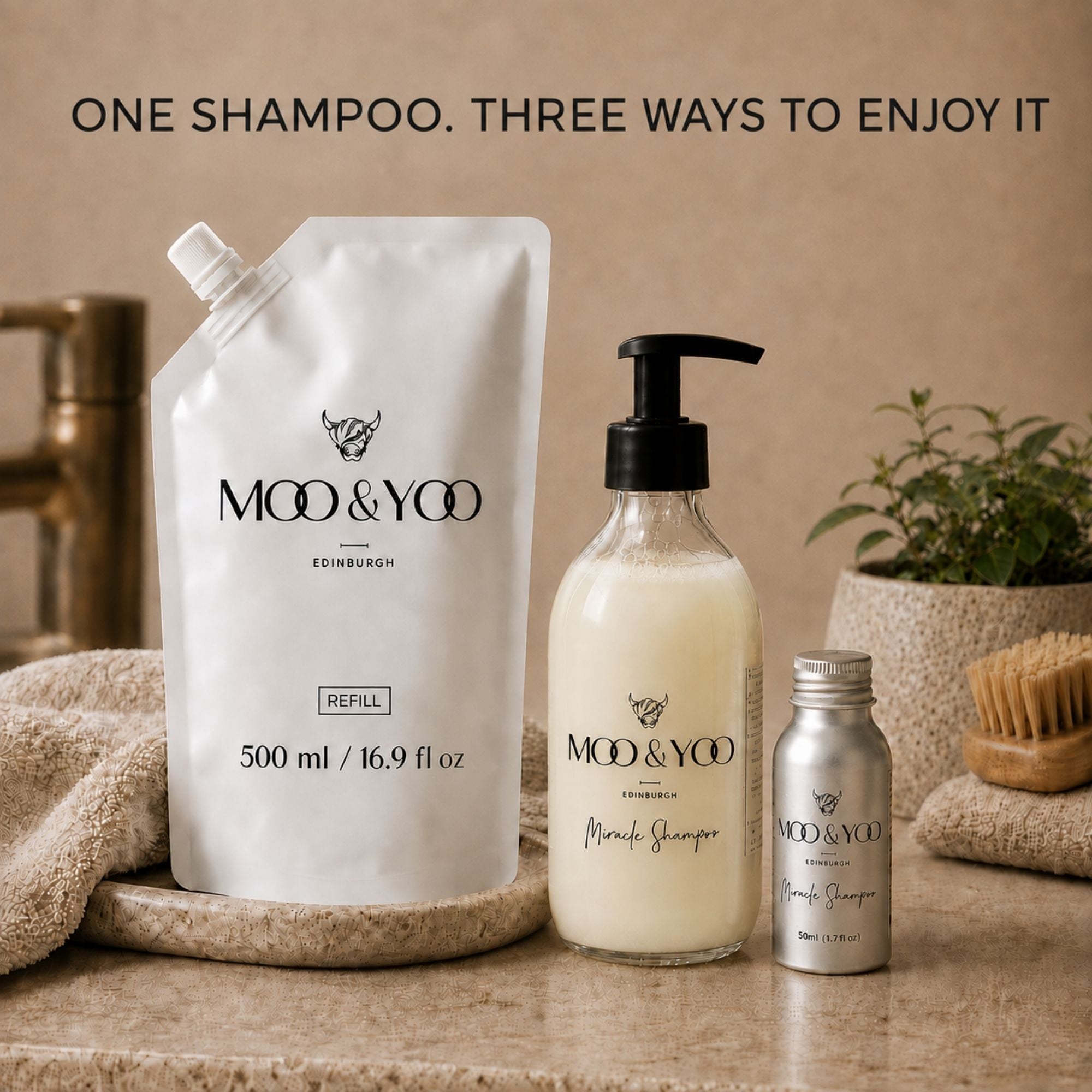 Three MOO & YOO Edinburgh shampoo products arranged on a stone surface: a large white refill pouch, a clear glass bottle with shampoo and black pump, and a small silver bottle. Text at the top reads 'ONE SHAMPOO. THREE WAYS TO ENJOY IT.