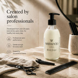 MOO & YOO Miracle Shampoo in a clear pump bottle, styled on a beige stone surface with salon tools like scissors, a comb, and a towel, alongside promotional text.