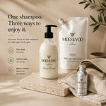 MOD & YOO Miracle Shampoo in dofferent sizes featuring a 250 ml pump bottle, a 500 ml refill pouch, and a small 50 travel mini bottle, styled on a stone slab with a beige towel and leafy accents against a warm beige background.l