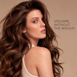 A woman with long, voluminous brown hair is shown in profile against a warm beige background, wearing a light beige ribbed tank top. The text on the right reads, 'VOLUME, WITHOUT THE WEIGHT.