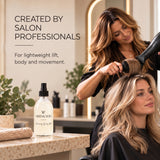 A salon scene shows a stylist using a hair dryer on a client's hair while a bottle of MOO&YOO volumising spray Styling Spray sits on the counter in the foreground. Text on the left reads 'CREATED BY SALON PROFESSIONALS' and 'For lightweight lift, body and movement.