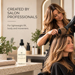 A salon scene showing a stylist using a hair dryer on a client's hair, with a bottle of Moo & Yoo Volumising spray mistl on a counter in the foreground and promotional text on the left saying Created by salon professionals for lightweight lift, body and movement