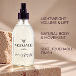 A clear glass spray bottle of MOO & YOO Volumising Spray Mist with a BLACKpump, set on a stone pedestal against a warm beige background with promotional text.