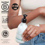 Person applying body lotion with a bottle labeled 'Moo & Yoo' on a light background, featuring sustainability logos.