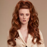 Female model with long wavy red hair with half tied into a high pony tail and half down in long flowing loose hollywood waves. Her hair is very shiny from using Moo and Yoo Miracle Conditioner, Mircle Milk and Mask. She is wearing a cream cord jacket buttoned up to a v shape. 