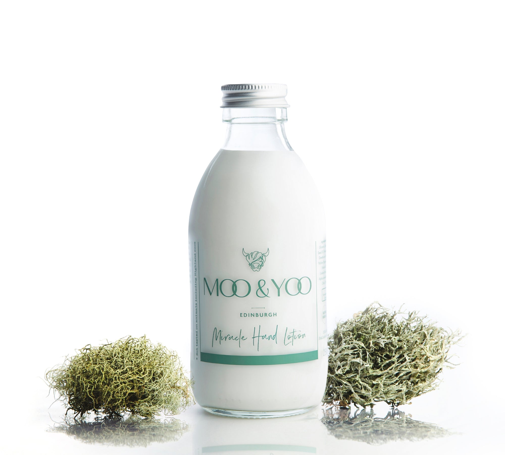 Glass bottle of Miracle Hand Lotion on a white background with a sprig of moss to each side.
