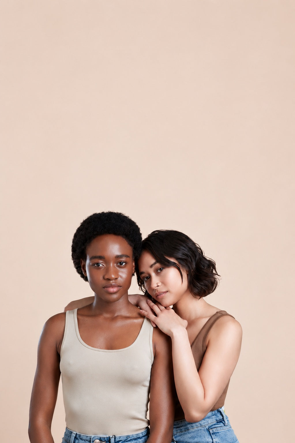 Two women with different hair types against a soft beige background, representing personalised professional haircare.