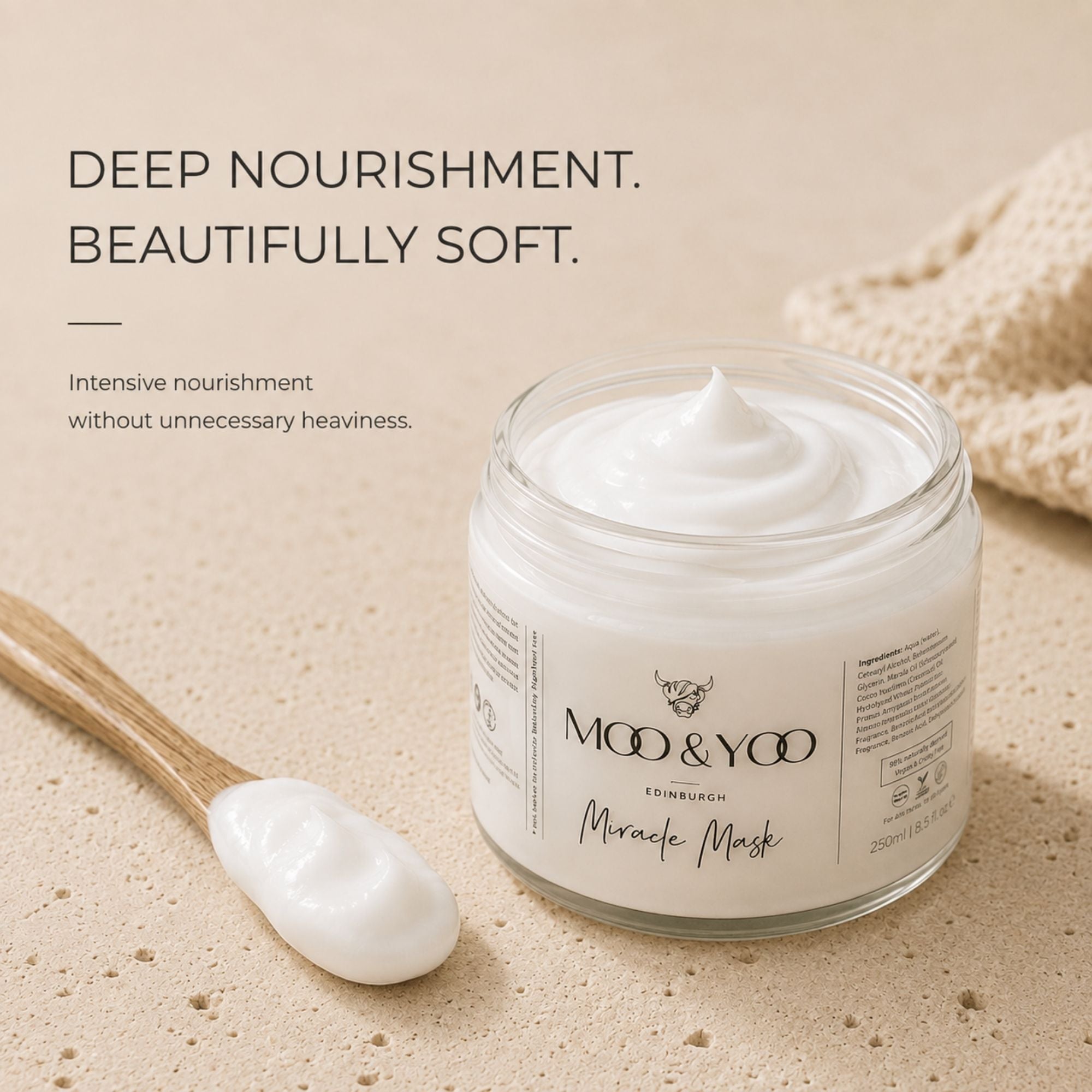 A jar of MOO & YOO  Miracle Mask cream shown on a warm beige textured surface with a wooden spoon holding some of the white mask cream. Text on the left reads 'DEEP NOURISHMENT. BEAUTIFULLY SOFT