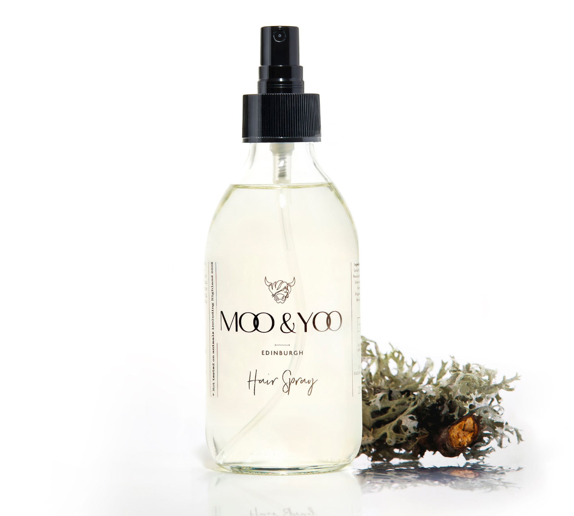 A glass bottle of Moo and Yoo Hair Spray on a white background with a sprig of Icelandic moss placed to one side